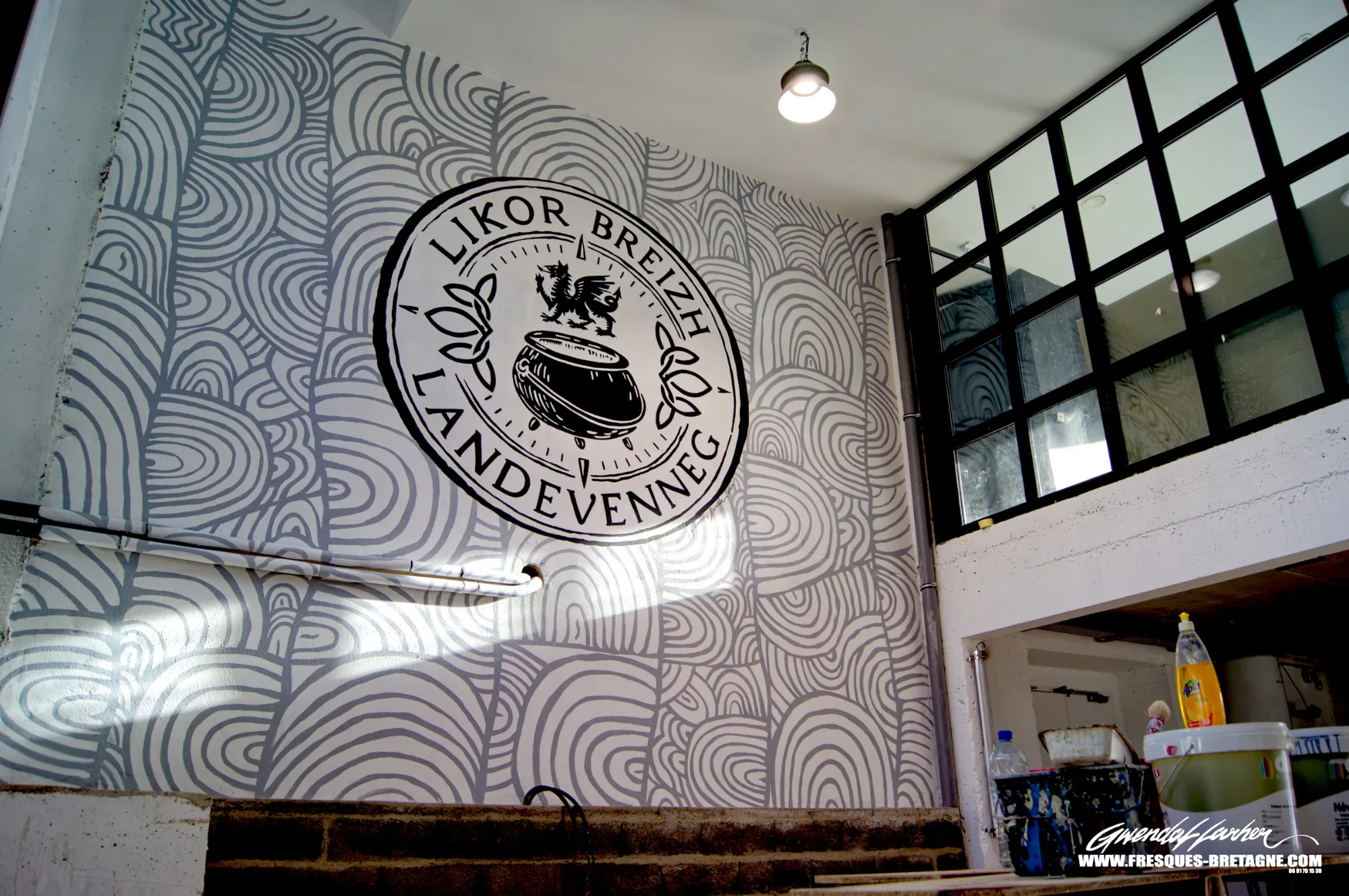 Fresque murale de motifs gravés néolithiques de Gavrinis autour du médaillon Likor Breizh Landévennec, décor d'entreprise pour une distillerie